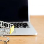 Shopping cart next to a laptop